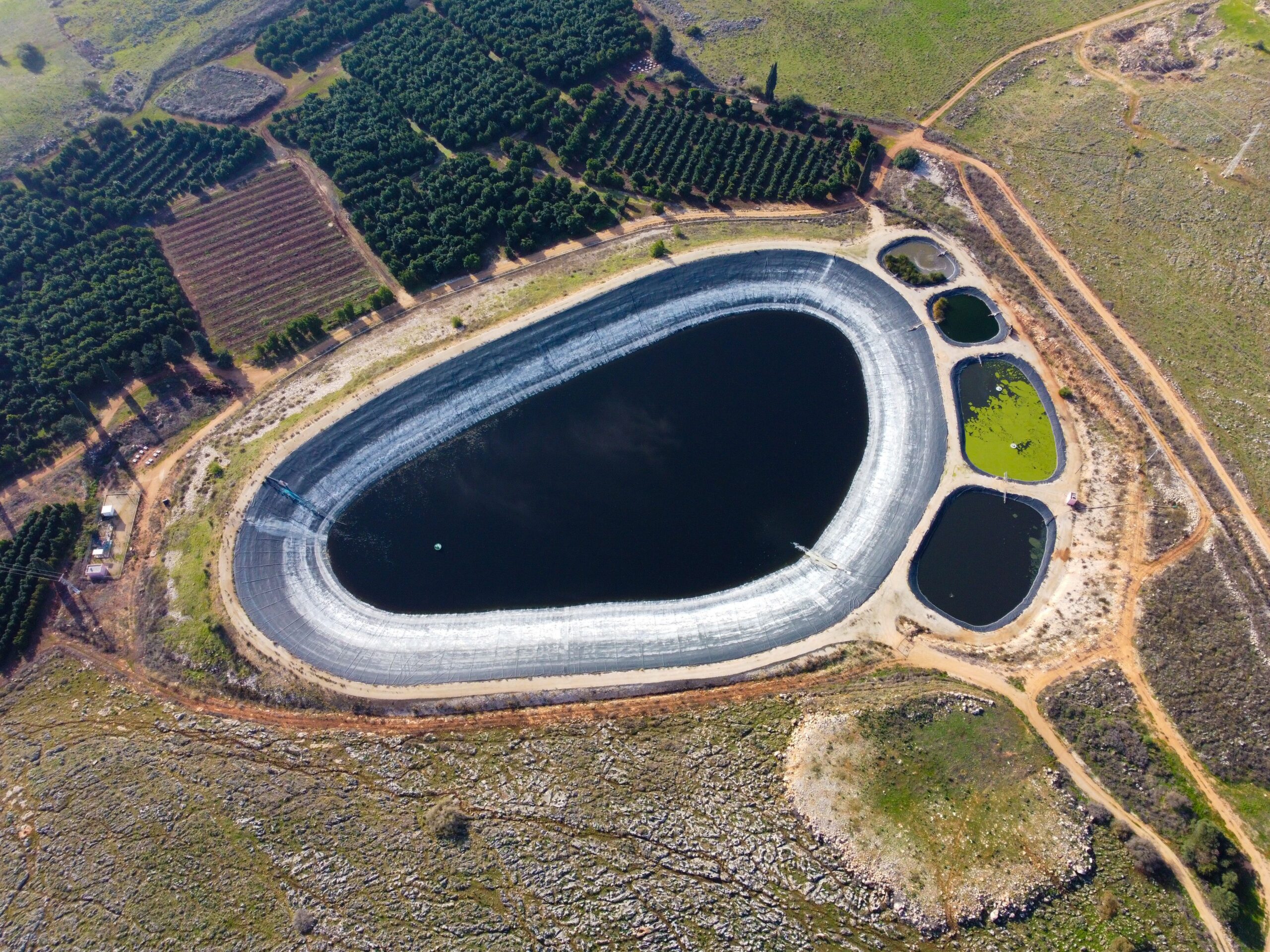 An image of irrigation Reservoirs that divided into several parts. One of the tinier reservoir has been infected by the algae bloom. If the algae blooms are left untreated, it will cause a severe drop on water quality, depending on the use of the reservoir.
